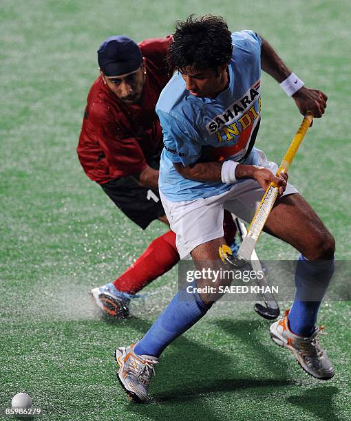 Indian player Gurbaj Singh vies for the ball with Kevinder Singh of Malaysia during the final of the Sultan Azlan Shah Cup field hockey match in...