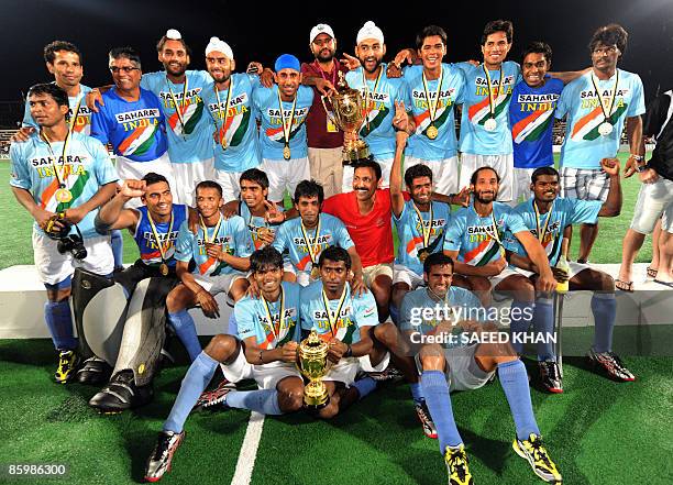 The Indian field hockey team celebrates with the winning trophy after defeating Malaysia in the final of the Sultan Azlan Shah Cup field hockey in...