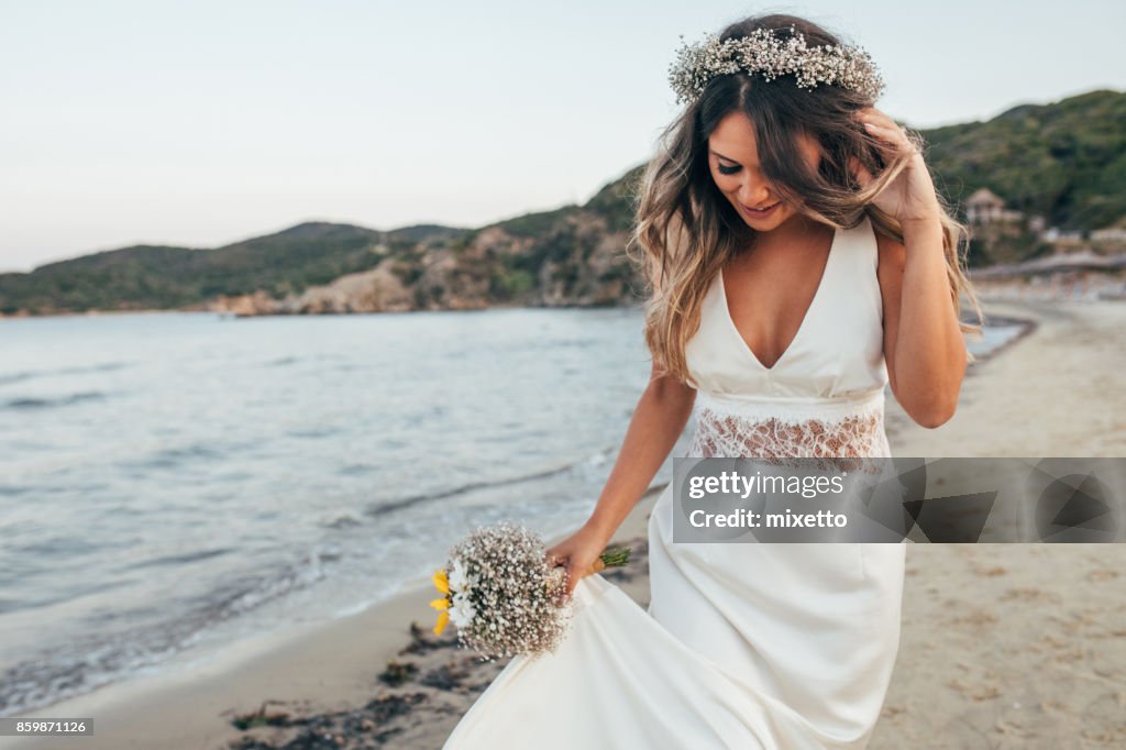 Sposa che cammina sulla spiaggia
