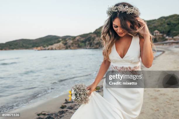 sposa che cammina sulla spiaggia - sposa foto e immagini stock