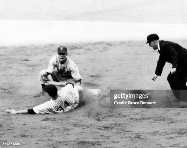 Pee Wee Reese of the Brooklyn Dodgers tags out Johnny Sturm of the New York Yankees as umpire Bill Grieve is there to make the call during Game 1 of...