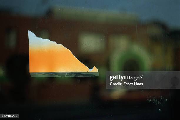 The torn corner is all that remains of a poster taped to a window, June 1970.