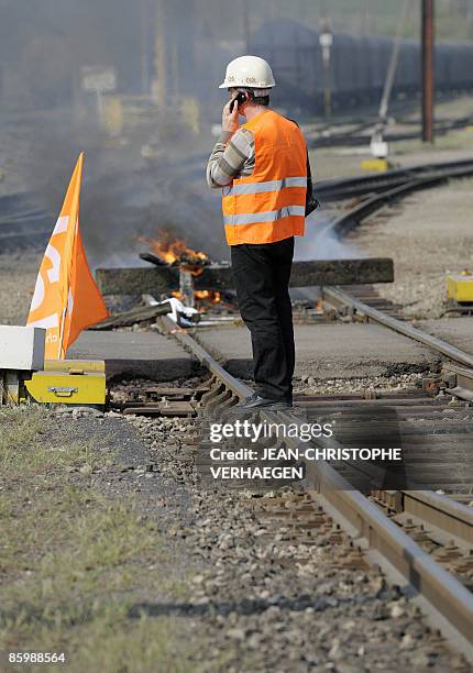 Man makes a phone call as Union trade members from an ArcelorMittal plant in Florange block the traffic at a train station to ask for negotiations...