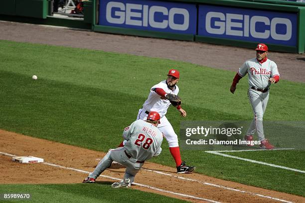 Outfielder Jayson Werth of the Philadelphia Phillies reaches base safely on an errant throw to firstbaseman Nick Johnson of the Washington Nationals...