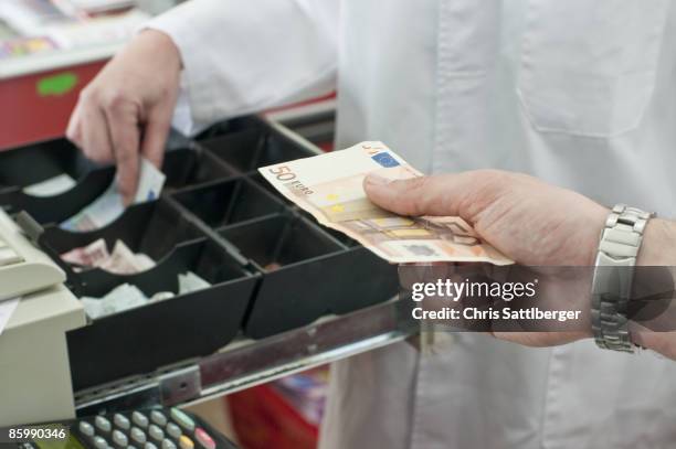 cash in hand of customer paying in supermarket - billet de 50 euros photos et images de collection