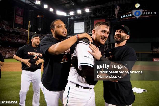 Yasmany Tomas, Jeff Mathis and Daniel Descalso of the Arizona Diamondbacks celebrate after defeating the Colorado Rockies in the National League Wild...