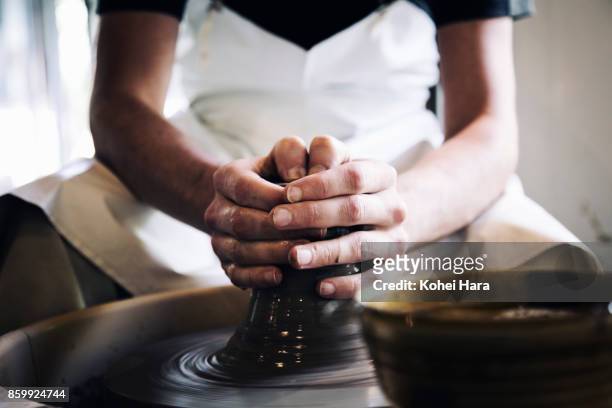 hands of man making ceramic work with potter's wheel - potters wheel stock pictures, royalty-free photos & images