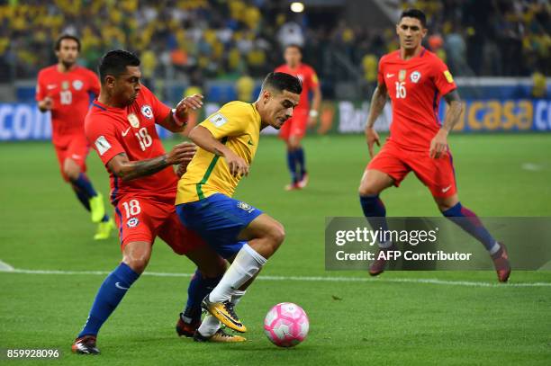 Brazil's Philippe Coutinho is marked by Chile's Gonzalo Jara during their 2018 World Cup qualifier football match in Quito, on October 10, 2017. /...
