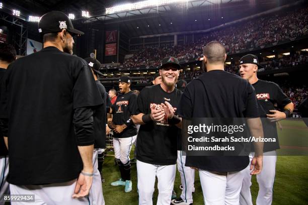 Chris Herrmann of the Arizona Diamondbacks celebrates with teammates after defeating the Colorado Rockies in the National League Wild Card Game at...