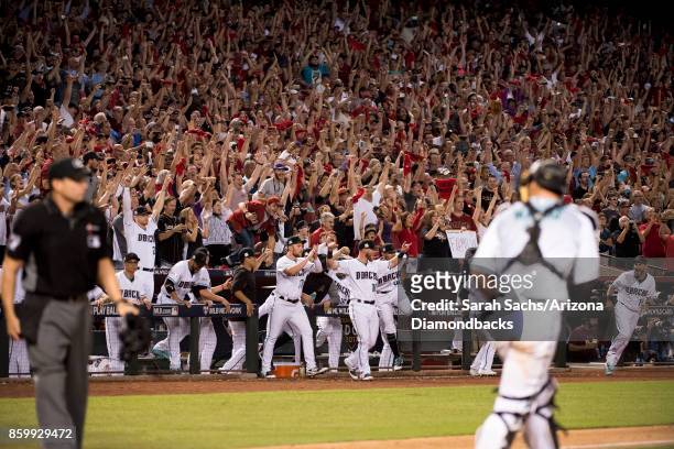 The Arizona Diamondbacks and fans celebrate after defeating the Colorado Rockies in the National League Wild Card Game at Chase Field on October 4,...