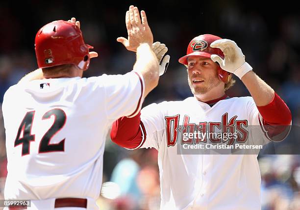 Mark Reynolds of the Arizona Diamondbacks is congratulated by teammate Chad Tracy after Reynolds hit a two-run home run against the St. Louis...