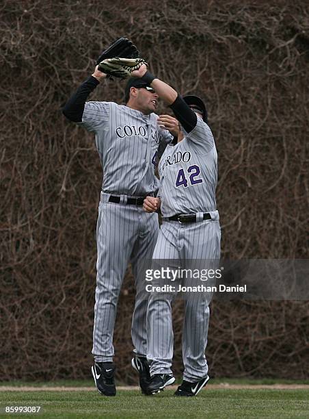 Seth Smith and Ryan Spilborghs of the Colorado Rockies, wearing jerseys on Jackie Robinson Day, avoid colliding as Spilborghs catches a fly ball...
