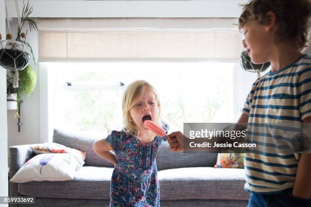 siblings share an ice lolly / ice block - girls licking girls stock pictures, royalty-free photos & images