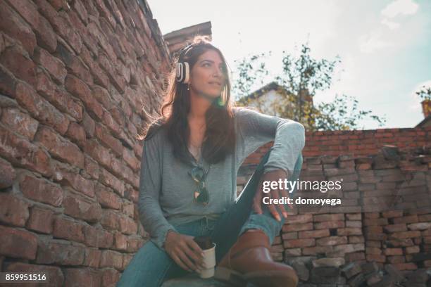 beautiful casual dressed woman listening to music - aparelho eletrónico de escuta imagens e fotografias de stock