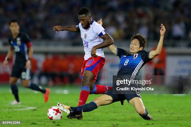 Duckens Nazon of Haiti is tackled by Genki Haraguchi of Japan during the international friendly match between Japan and Haiti at Nissan Stadium on...