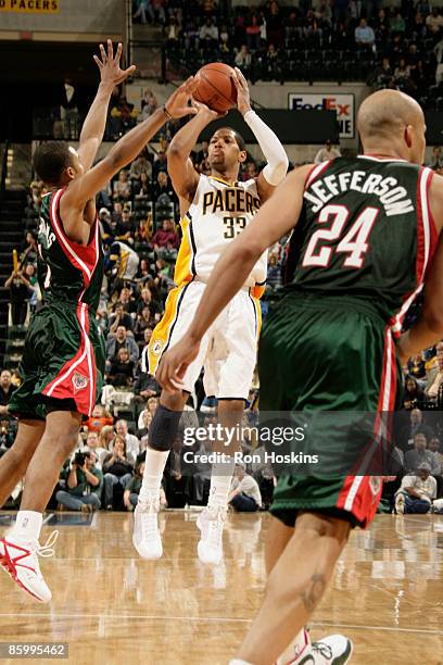 Danny Granger of the Indiana Pacers shoots over Ramon Sessions and Richard Jefferson of the Milwaukee Bucks at Conseco Fieldhouse on April 15, 2009...