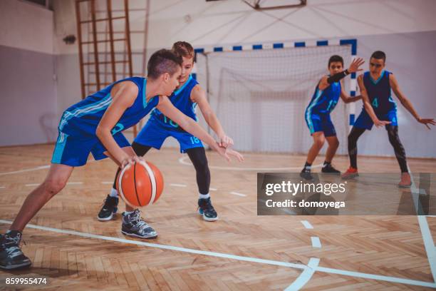 jeunes garçons jouant au basketball - stage sportif photos et images de collection