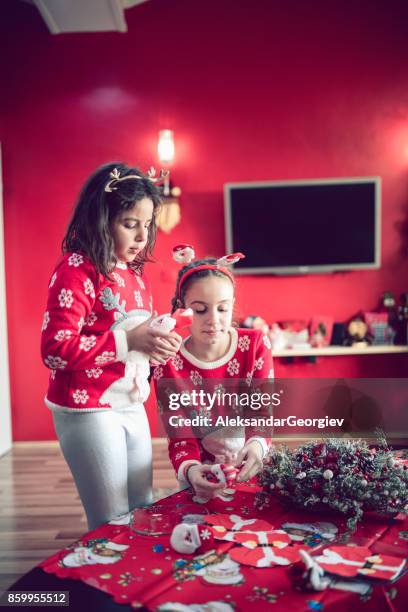 zwei kleine schwestern arrangieren ihre handgemachten weihnachtskarte für santa - child cutting card stock-fotos und bilder