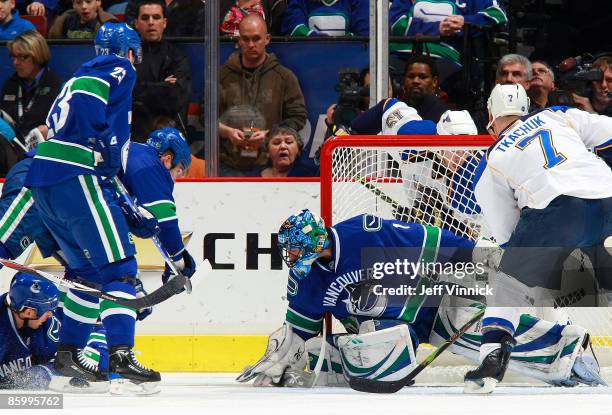 Roberto Luongo of the Vancouver Canucks gets his paddle down to make a save in front of teammates Alexander Edler, Ryan Johnson and Shane O'Brien...