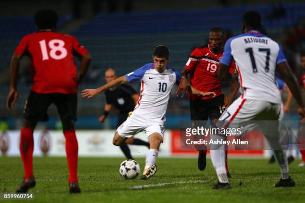 Christian Pulisic of the United States mens national team scores a goal as Kaven George of Trinidad and Tobago attempts to block the shot during the...
