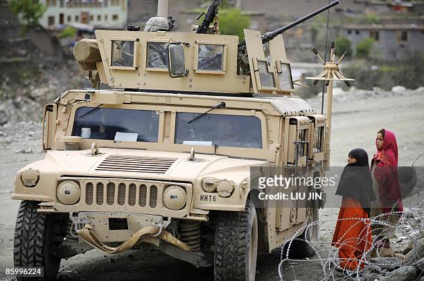 Afghanistan-unrest-military-security, FOCUS by Charlotte McDonald-Gibson Two Afghan girls look at a US Army Humvee from 1st Infantry Division on a...