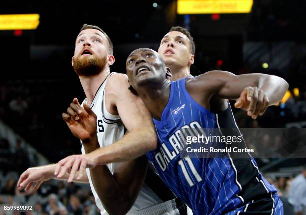 Bismack Biyombo of the Orlando Magic boxes out Matt Costello of the San Antonio Spurs as Aaron Gordon of the Orlando Magic looks on from behind at...