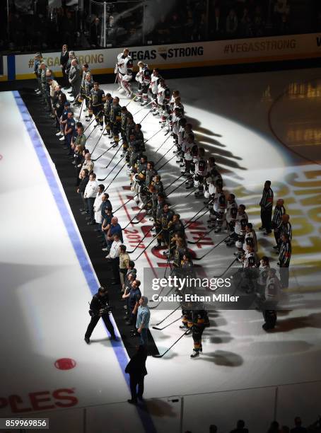 Police, fire and medical personnel line up on the ice in front of the Vegas Golden Knights and the Arizona Coyotes before the Golden Knights'...
