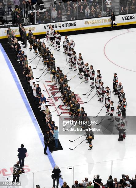 Police, fire and medical personnel line up on the ice in front of the Vegas Golden Knights and the Arizona Coyotes before the Golden Knights'...