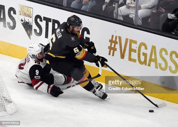 Colin Miller of the Vegas Golden Knights skates with the puck behind the net against Clayton Keller of the Arizona Coyotes during the Golden Knights'...