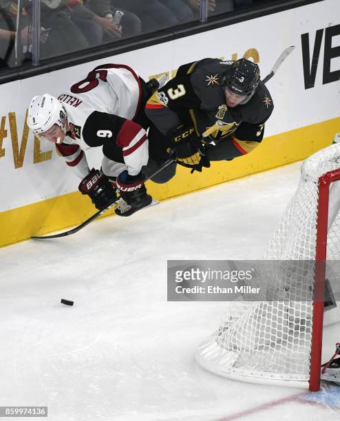 Clayton Keller of the Arizona Coyotes and Brayden McNabb of the Vegas Golden Knights dive after the puck behind the net during the second period of...