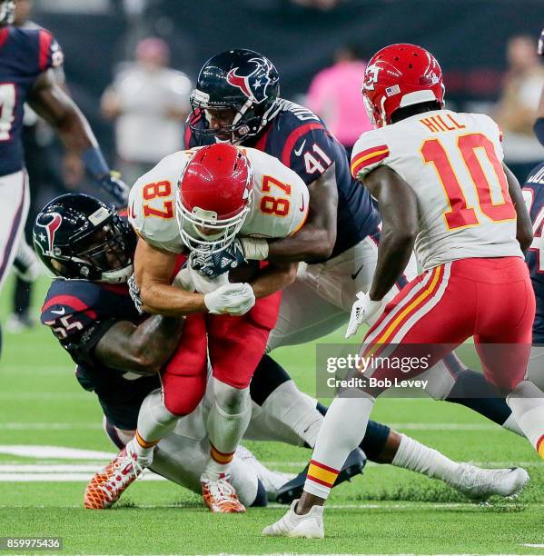 Travis Kelce of the Kansas City Chiefs is tackled by Benardrick McKinney of the Houston Texans and Zach Cunningham as Tyreek Hill looks on at NRG...
