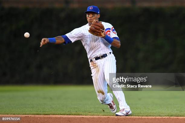 Addison Russell of the Chicago Cubs makes a throw to first base during game three of the National League Divisional Series against the Washington...