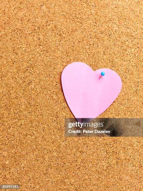 heart shaped adhesive note on notice board. - notice board stockfoto's en -beelden