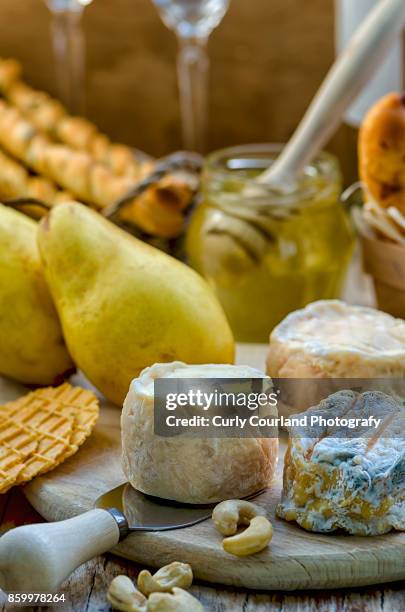 french artisanal goat cheese crottin de chavignol made in ukrainian farm with pears, grissini bread sticks, waffles, honey, white wine and cashew - chavignol stock pictures, royalty-free photos & images