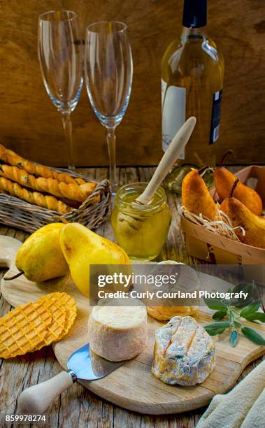 french artisanal goat cheese crottin de chavignol made in ukrainian farm with pears, grissini bread sticks, waffles, honey, white wine and cashew - chavignol stock pictures, royalty-free photos & images