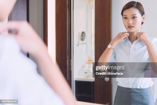 mujer mirando al espejo en el baño - vestirse fotografías e imágenes de stock