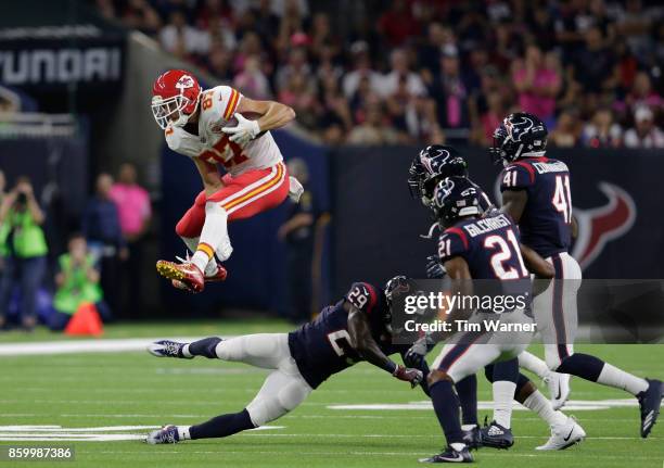 Travis Kelce of the Kansas City Chiefs hurdles Andre Hal of the Houston Texans in the first half at NRG Stadium on October 8, 2017 in Houston, Texas.