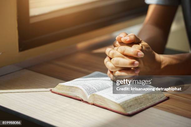 a man reading the holy bible. - catholicism stock-fotos und bilder