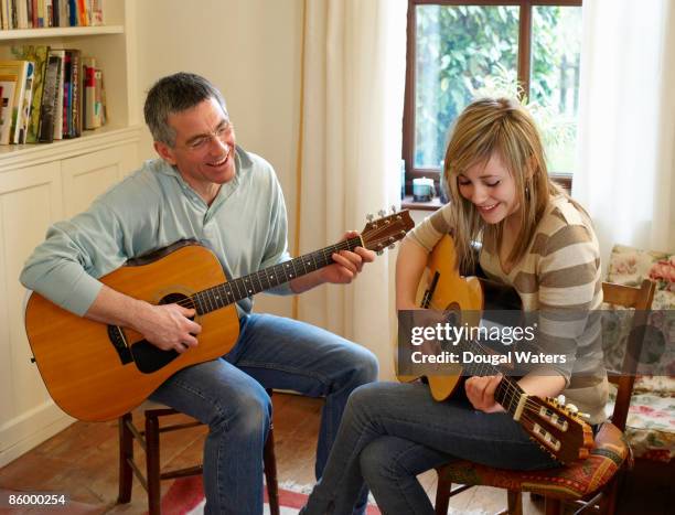 father and daughter playing guitars. - father daughter guitar stock pictures, royalty-free photos & images