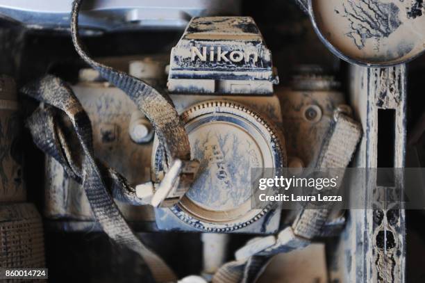 The old Nikon camera of photographer Daniele Dainelli covered in mud hit by the flood of Livorno is displayed on October 10, 2017 in Livorno, Italy....