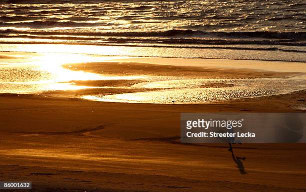 Woman runs down the beach at sunrise before the start of the first round of the Verizon Heritage at Harbour Town Golf Links on April 16, 2009 in...