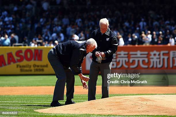 Former New York Yankees Don Larsen and Whitey Ford take dirt from the pitchers mound during an opening day ceremony at the new Yankee Stadium on...