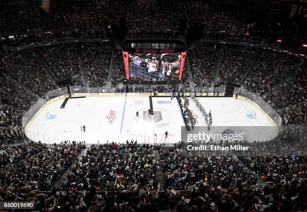 Police, fire and medical personnel line up on the ice in front of the Vegas Golden Knights and the Arizona Coyotes before the Golden Knights'...