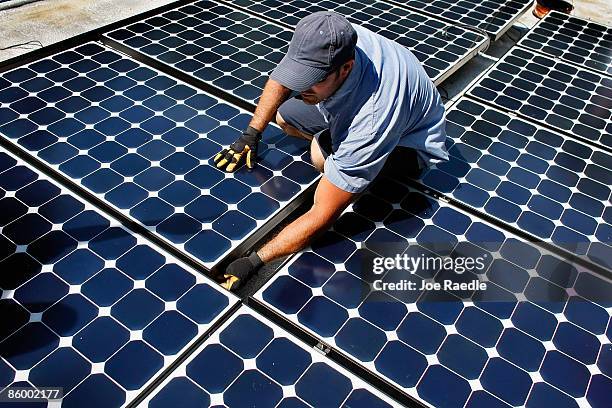 Damon Corkern, who works for ECS Solar Energy Systems, Inc, installs a solar panel system on the roof of a home on April 16, 2009 in Gainesville,...