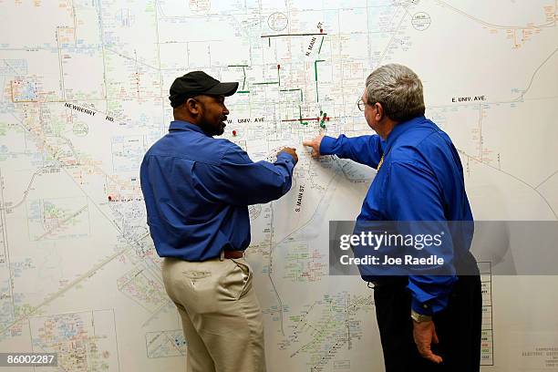 Jowell Morgan and Dan Jesse pinpoint a solar panel installation on the cities electrical grid map in the control room of the Gainesville Regional...