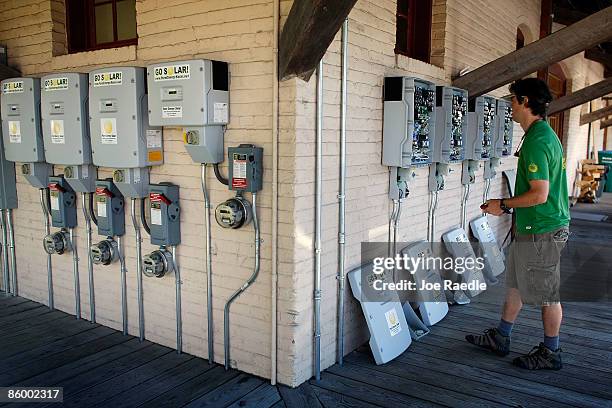 Wayne Irwin, who works for Pure Energy Solar, works on the control panels of a solar panel system installed on the roof of a business on April 15,...