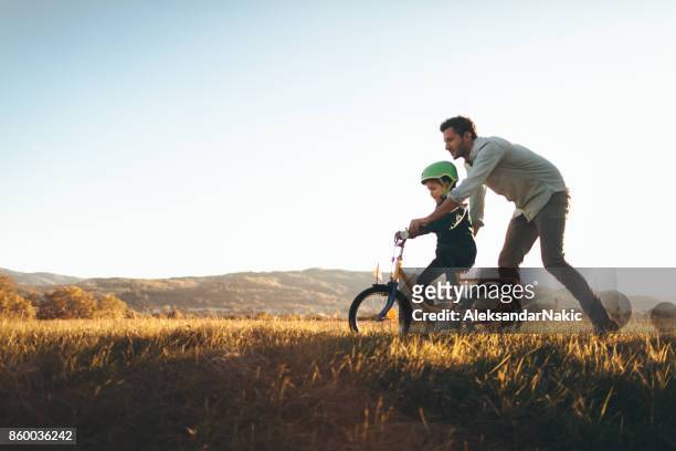 father and son on a bicycle lane - prop stock pictures, royalty-free photos & images