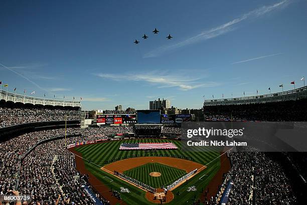 Fighter jets fly over as recording artist Kelly Clarkson sings the National Anthem while members of the military hold a giant American flag before...