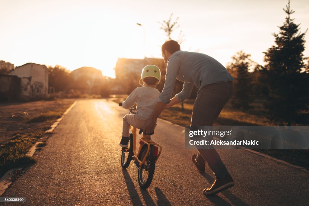 Padre e figlio su una pista ciclabile