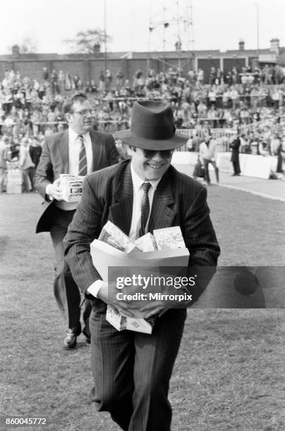 Pop star and Watford FC Chairman, Elton John, handing out Easter eggs to fans. Watford v Southampton football match, 6th April 1985.